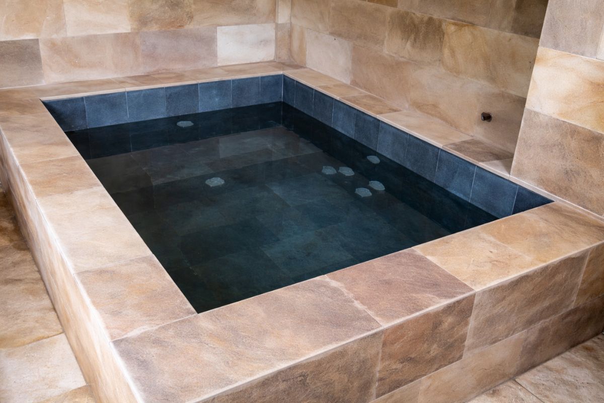 Morador transforma quartinho esquecido em spa com banheira de hidromassagem de alvenaria para 6 pessoas, revestimento em pedra, iluminação quente e água aquecida (2)