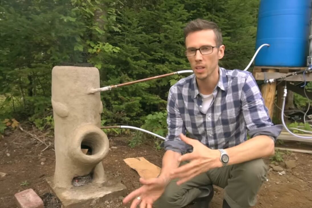 Calentador de agua fuera de la red en Quebec utiliza estufa cohete, barril elevado, tubos de cobre y termostato para calentar baño sin propano, bomba o electricidad, priorizando autonomía, eficiencia y atención a la seguridad en el uso diario.