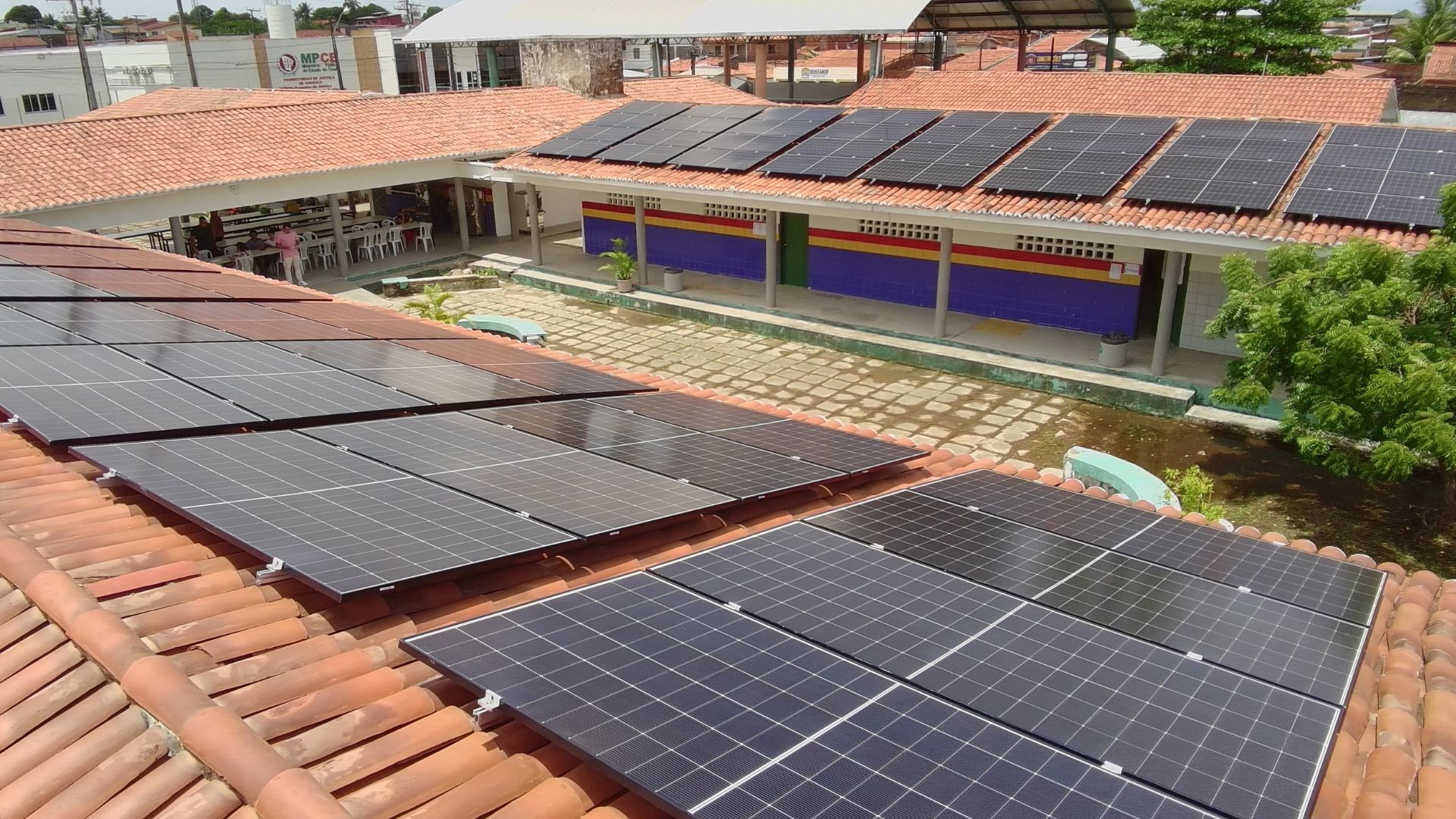 Painéis de energia solar instalados no telhado de escola municipal em Caucaia, no Ceará, como parte do projeto que já beneficia 27 unidades da rede pública.