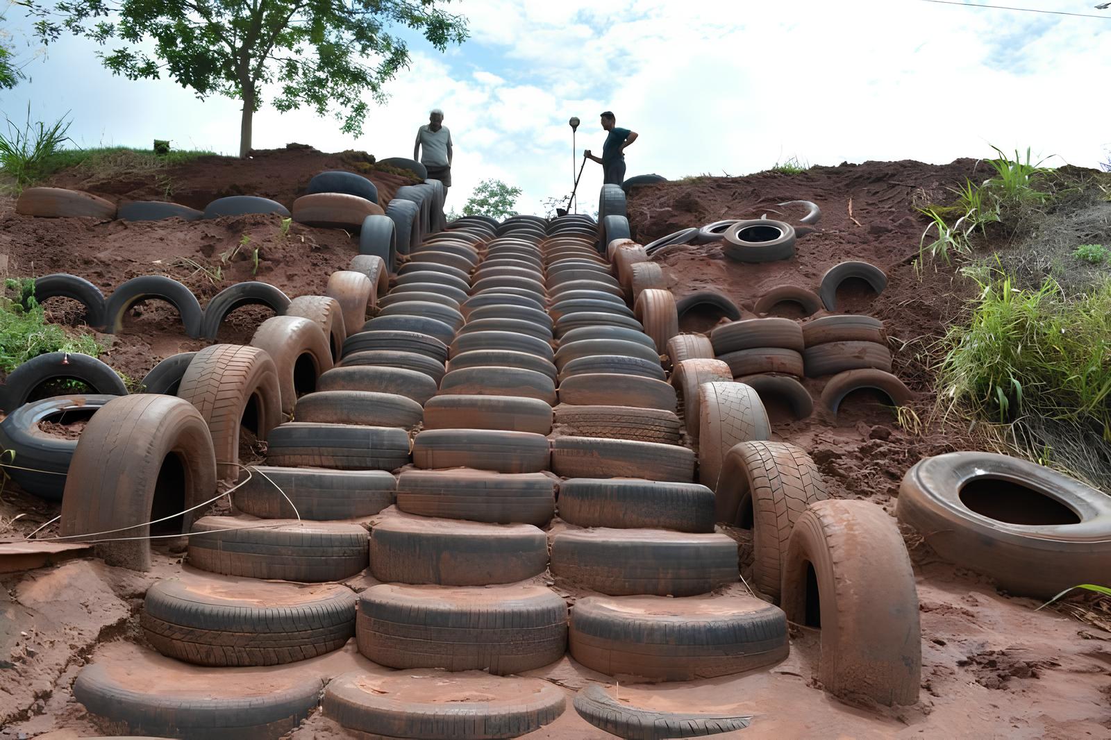 Um morador aproveita pneus velhos descartados, empilha e preenche com terra para criar uma escadaria funcional em um barranco íngreme e transformar lixo urbano em atalho usado por toda a vizinhança