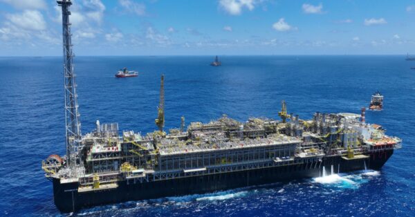 Plataforma offshore da Petrobras operando em alto-mar no Brasil, com estruturas industriais e navios de apoio ao redor, representando a produção de petróleo e gás no pré-sal.