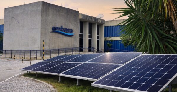 Sede da Embasa na Bahia com painéis de energia solar instalados em frente ao prédio, representando o avanço da transição energética e uso de fontes renováveis pela empresa.